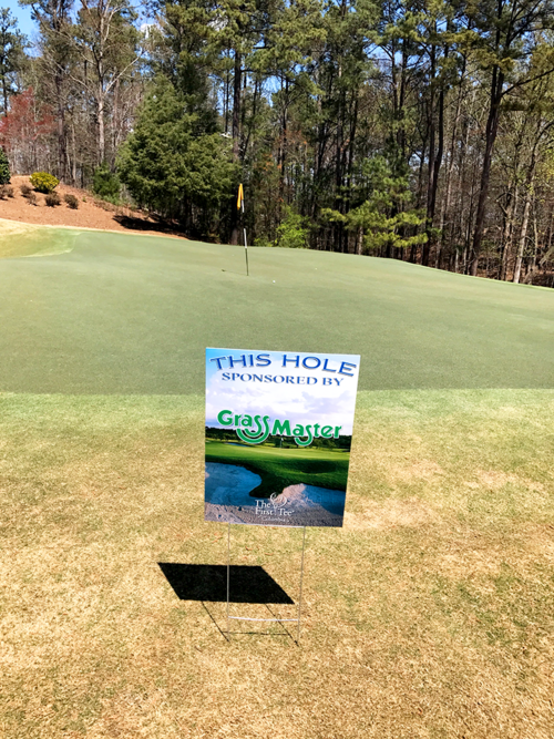 grass master sign at a golf course